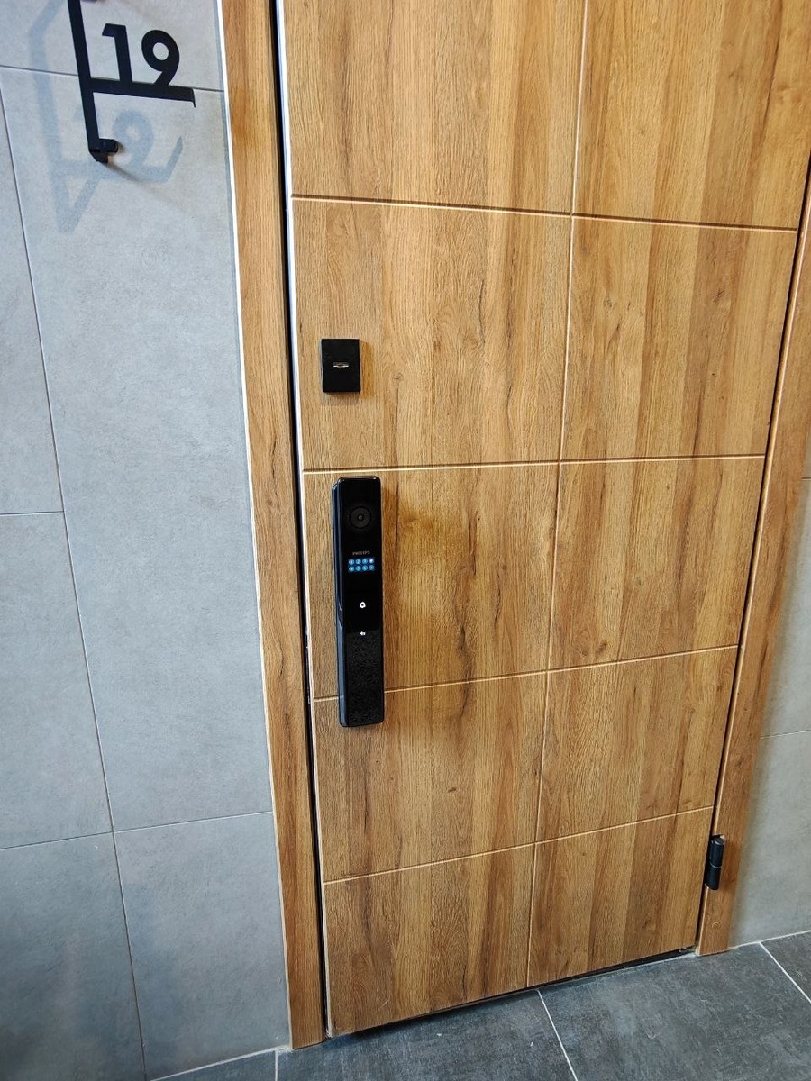 Puerta símil roble con cerradura inteligente Philips instalada
